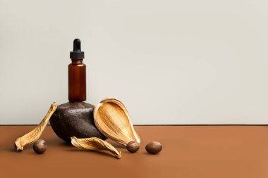 Kahverengi bir şişe, siyah bir taşın üzerine damlatan bir şişe ve kahverengi ve gri bir arka plan.