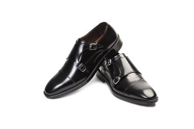 Beyaz arka planda izole edilmiş bir çift siyah keşiş ayakkabısı.