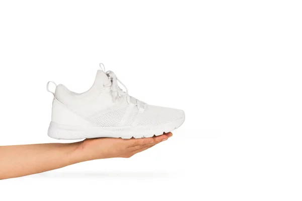 Una Sneaker Bianca Una Mano Donna Uno Sfondo Bianco — Foto Stock