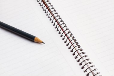 A blank notebook and a pencil in a close up view