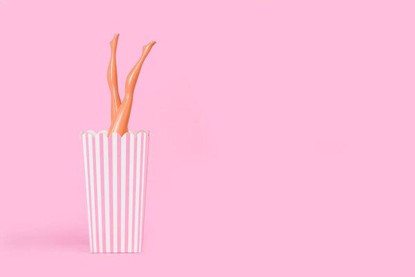 Кукольные ножки в полосатом белом и розовом ведре на розовом фоне