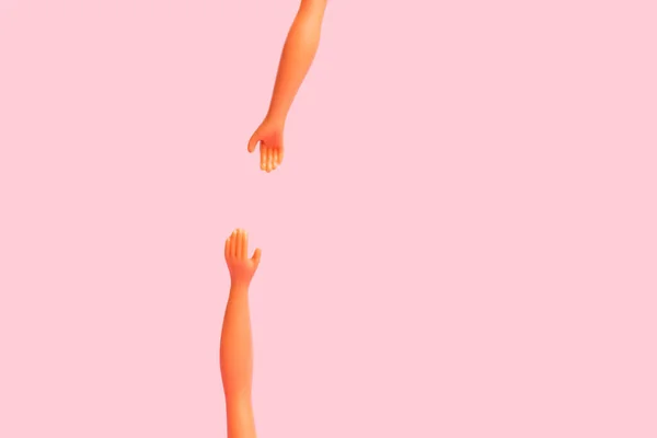 Дві Руки Ляльки Намагаються Зловити Один Одного Рожевому Тлі Копіювальним — стокове фото