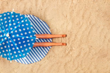 Şemsiyenin altında güneşlenen bir bebek.