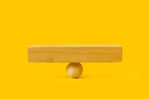 木製の球と黄色の背景に正方形の木製のベース — ストック写真