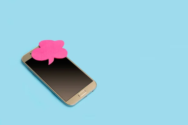 浅蓝色背景的带聊天泡泡的智能手机 — 图库照片