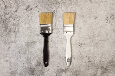 Taş zeminde beyaz ve siyah boya fırçaları