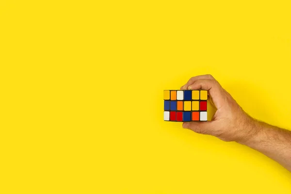 Férfi Kéz Lyukas Rubic Kocka Egy Sárga Háttér Másolási Hely — Stock Fotó