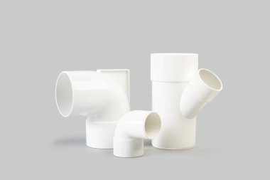 Gri arkaplanda kopyalama alanı olan beyaz plastik bağlantı boruları