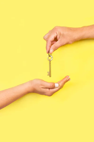 Man Hand Giving Key Woman Hand Yellow Background Copy Space — 스톡 사진