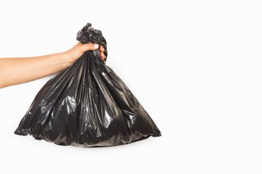 Beyaz bir arkaplanda siyah plastik poşet tutan bir kadın.