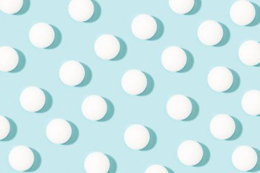 White ping pong balls on a light blue background
