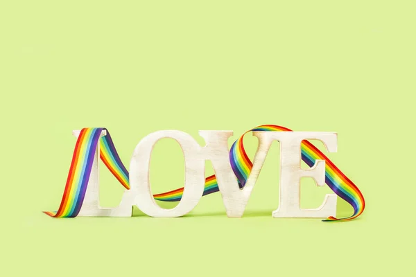 Love Word Made Wooden Letters Rainbow Colors Ribbon Green Background — Stock fotografie