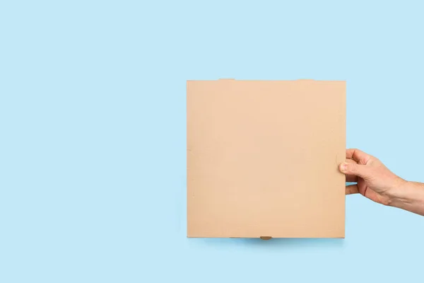 Mann Hält Eine Braune Pizzaschachtel Auf Hellblauem Hintergrund Mit Kopierraum — Stockfoto