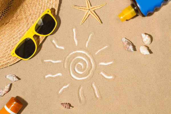 Sun tan lotion bottles and a drawing of the sun on the sand