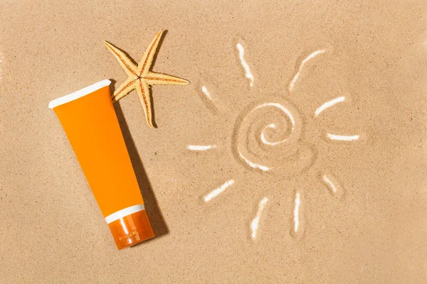 A sun tan lotion and a drawing of the sun on the sand in a top view