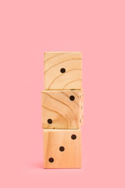 Fotokopi alanı olan pembe bir zemin üzerinde bir yığın ahşap zar.