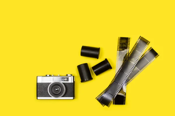 带复制空间的黄色背景上的老式摄影相机和底片底片 — 图库照片