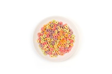 Meyve aromalı mısır gevrekleri beyaz bir tabakta beyaz bir zemin üzerinde üstten bakıldığında