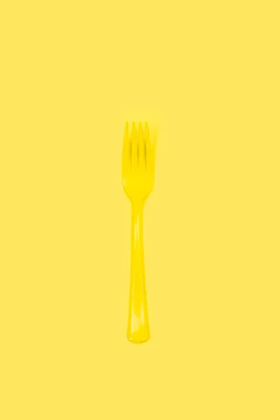 Jednorazowy Żółty Plastikowy Widelec Żółtym Tle Przestrzenią Kopiowania — Zdjęcie stockowe