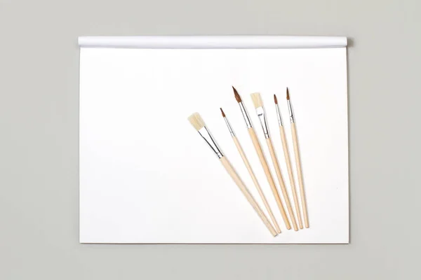 Künstlerische Pinsel Aus Holz Auf Weißem Papierblock Mit Kopierraum — Stockfoto