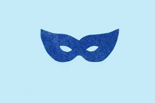 Blue party glitter eye mask on a light blue background with copy space