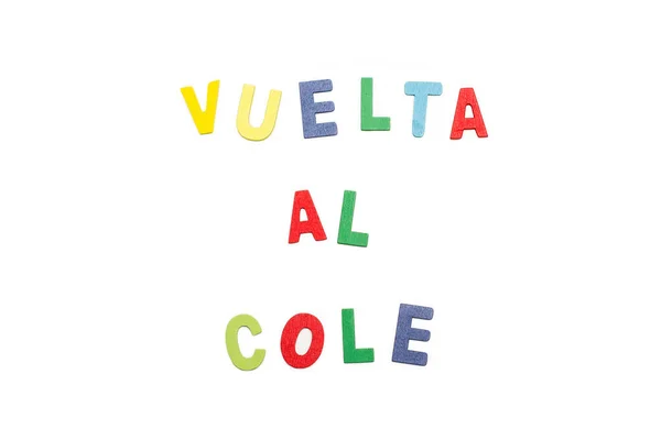 Vuelta al cole write with colored toy wooden letters on a white background (Back to school)