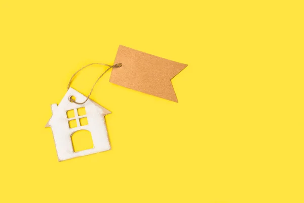 Картонний Будинок Коричневою Порожньою Паперовою Етикеткою Жовтому Тлі Пробілом Копіювання — стокове фото