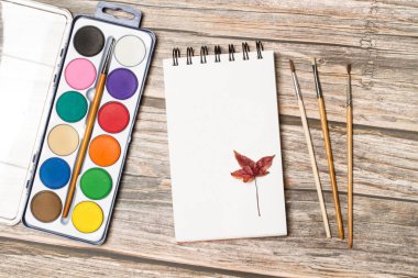 Bir palet suluboya ve fırça ahşap bir masa üzerinde üst bir görünüm