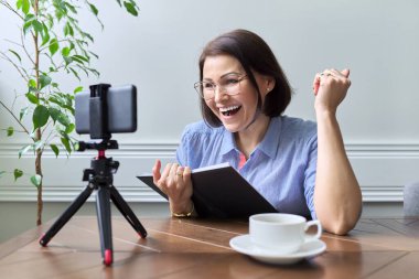 Orta yaşlı kadın öğretmen, iş kadını akıllı telefon kullanıyor.