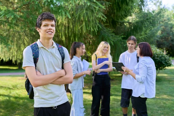 Πορτρέτο του μαθητή στο πάρκο πανεπιστημιούπολη, ομάδα εφήβων με φόντο το δάσκαλο — Φωτογραφία Αρχείου