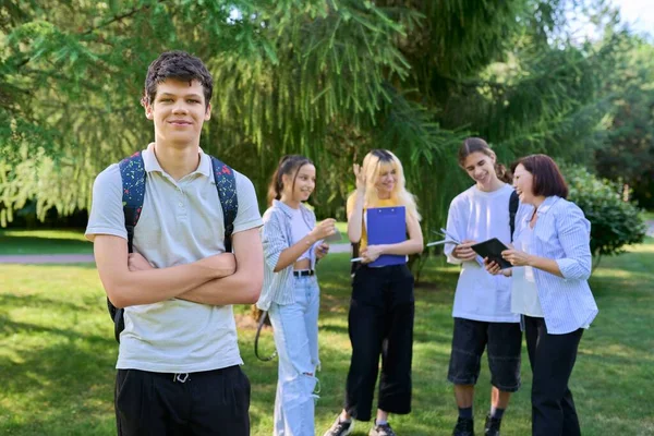 Portrait of male student in park campus, group of teenagers with teacher background — Stock Photo, Image