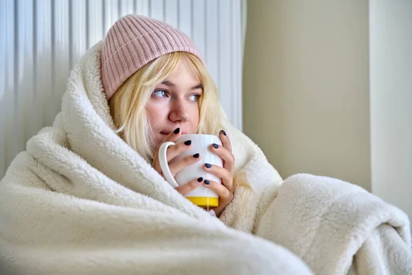 Νεαρή έφηβη ζεσταίνεται με κουβέρτα, καλοριφέρ θέρμανσης, ζεστό τσάι — Φωτογραφία Αρχείου