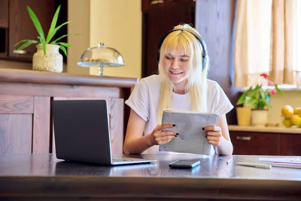 Estudiante en auriculares usando un portátil, estudiando en casa —  Fotos de Stock