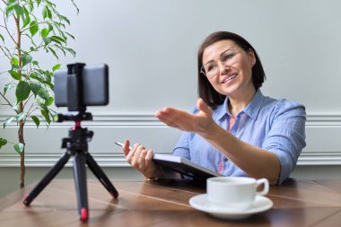 Orta yaşlı kadın öğretmen, iş kadını akıllı telefon kullanıyor.