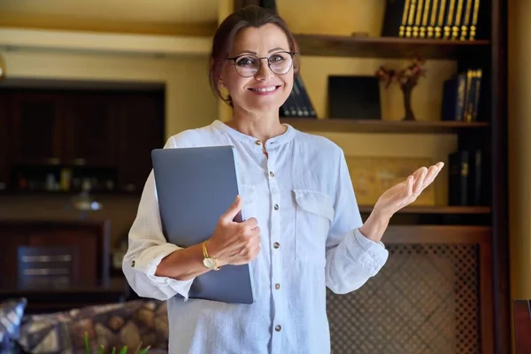 Портрет зрілої ділової жінки в окулярах з ноутбуком в руках — стокове фото