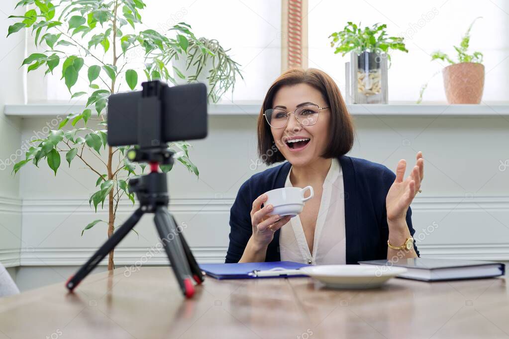 Middle aged business woman, counselor, mentor in a video meeting, using a smartphone