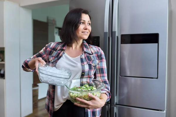 Жінка середнього віку на кухні з салатом і мискою льоду на кухні — стокове фото