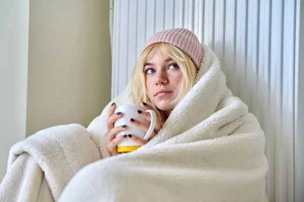 Νεαρή έφηβη ζεσταίνεται με κουβέρτα, καλοριφέρ θέρμανσης, ζεστό τσάι — Φωτογραφία Αρχείου