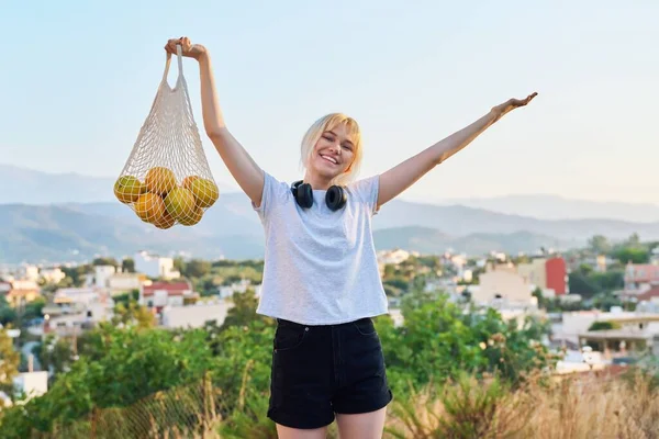 Жінка-підліток з екологічно чистим сітчастим мішком з органічних апельсинів ферми — стокове фото