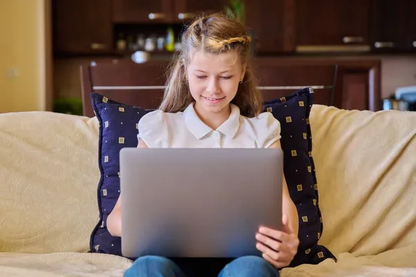 Bambino ragazza con computer portatile a casa sul divano — Foto Stock