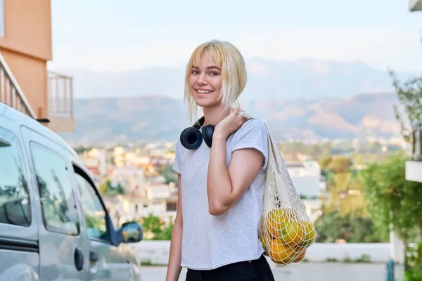 Портрет жінки-підлітка з апельсинами в екологічно чистій сітчастій сумці — стокове фото