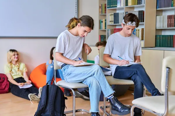 Skupina dospívajících studentů studuje společně v knihovně. — Stock fotografie
