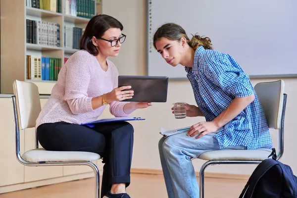 Žena školní psycholog mluví a pomáhá studentovi, dospívající muž — Stock fotografie