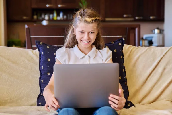 Bambino ragazza con computer portatile a casa sul divano — Foto Stock