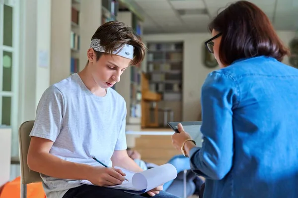 Kobieta szkoła psycholog rozmawia i pomaga student, nastoletni mężczyzna — Zdjęcie stockowe