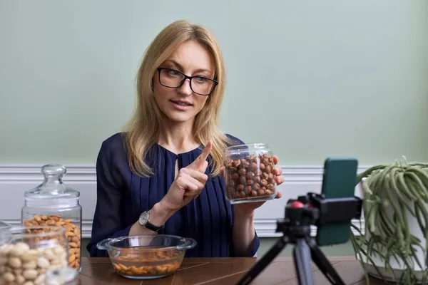Женщина записывает видео о орехах, питании, здоровой пище. — стоковое фото