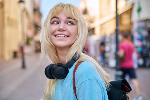Venkovní portrét šťastně se usmívající dospívající dívky, blondýna se sluchátky — Stock fotografie
