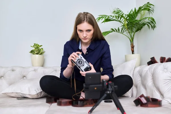 Jonge vrouw fotograaf met vintage camera opname video op smartphone — Stockfoto