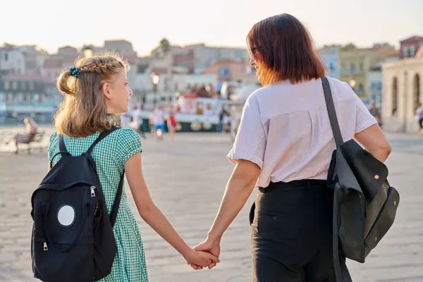 Mama i córka dziecko z plecakiem trzymające się za ręce, widok z tyłu — Zdjęcie stockowe