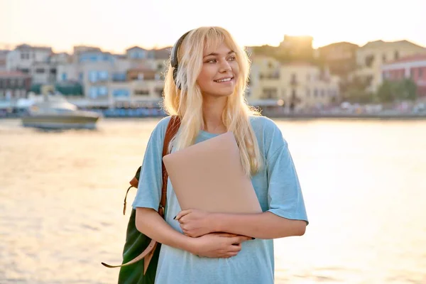 Retrato ao ar livre de adolescente estudante em fones de ouvido com mochila e laptop — Fotografia de Stock